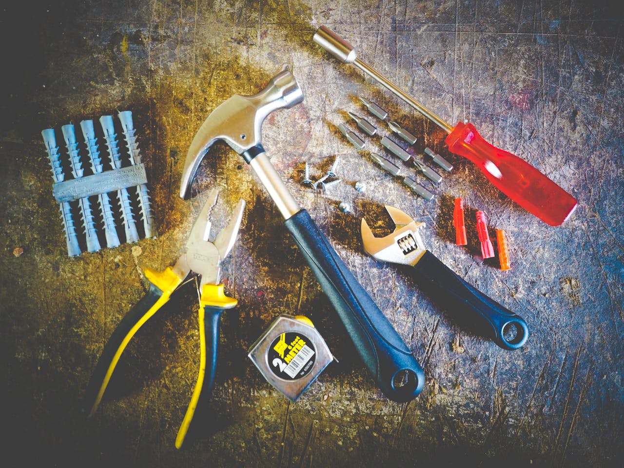 heros-img Collection of hand tools including hammer, screwdriver, and pliers in a workshop setting.
